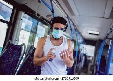 An urban man with a medical mask, rides public transport and uses hand sanitizer - Shutterstock ID 1780916309