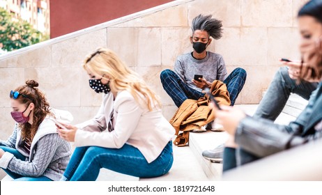 Urban millennial people using smart phones with face mask on Covid second wave - Serious guy watching news on mobile smartphone - College students sitting at university break - Bright contrast filter