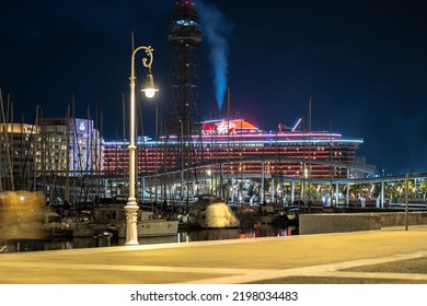 Urban Night City Life In Barcelona, Illuminated Port Or Harbor. Yacht With Water Reflection On Sea. Barcelona, Spain - May 14, 2022