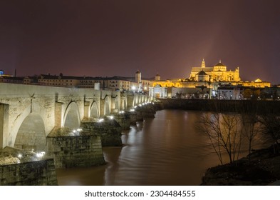 Urban night landscape, view of the city of Cordoba, Spain, with the Roman bridge in the foreground and the Mosque-Cathedral in the background - Shutterstock ID 2304484555