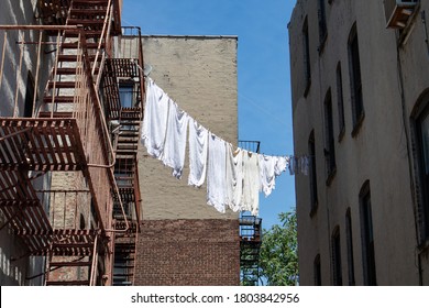Urban Outdoor Clothes Line with White Clothes and Fire Escapes on New York City Apartment Buildings