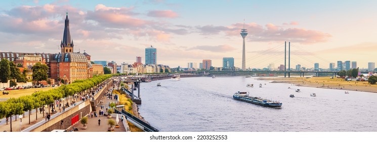 Urban panoramic cityscape view of Dusseldorf old town and transportation waterway of the whole of Germany - the Rhine River, along which large barges and small ships are sailing - Powered by Shutterstock