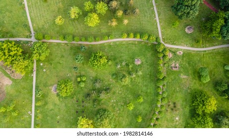 Urban Park With Meadow, Trees And Paths. Top View Aerial Photo From Flying Drone Of A City Park With Walking Path And Green Zone Trees In Evening Time.