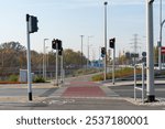 Urban pedestrian and cycle crossing with red cycle lane and traffic lights on quiet mornings. Concept for urban infrastructure, road safety and traffic organisation. High quality photo