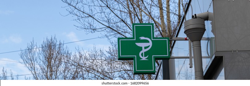 Urban Pharmacy Or Drug Store Sign, Cross Green Sign Of Pharmaceutical Drugstore, Led Display Green Cross On The Wall In The City Street, Copy Space.