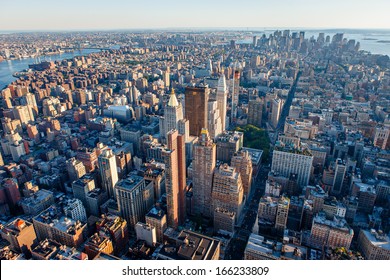 Urban photography of Manhattan showcasing New York cityscape and its buildings and skyscrapers: Midtown, Chelsea, Lower Manhattan, East Village, Financial District and Brooklyn in the distance.