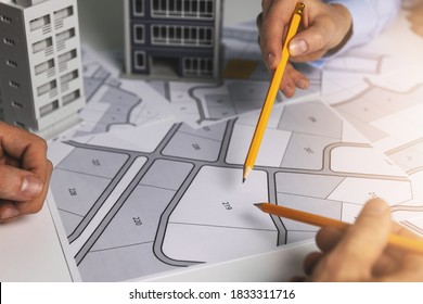 urban planning - people discussing about territory building plots on cadastral map for apartment building construction - Shutterstock ID 1833311716