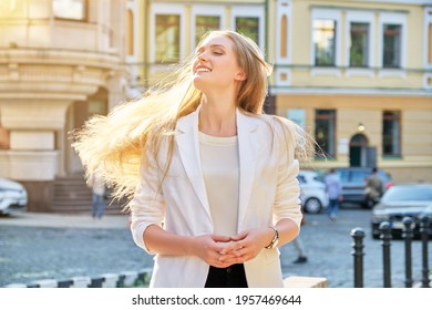 Urban Portrait Of Beautiful Young Blonde Woman With Long Hair Flying In Wind