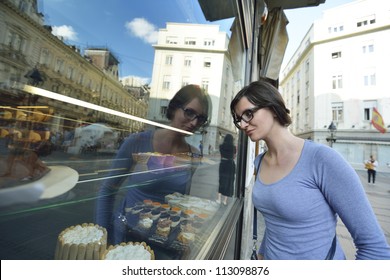 Urban Scene Of Young Woman In Front Of Sweet Candy Food Store Window