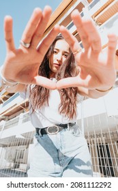 Urban Shot Of A Modeling Young African Woman With Long Hair Smiling And Making Poses To Camera. City Urban Concept. Happy Day On The City, White Shirt Blue Jeans. Modern Outfit Styling. Street Life.