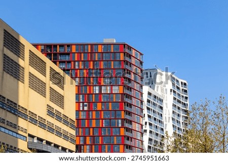 Urban skyline presenting diverse modern architecture and a distinctive red and orange apartment buildings in Rotterdam, Netherlands.