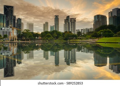 Urban skyscrapers with reflection on lake water in the morning