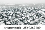 Urban sprawl expansion row of suburban houses, residential streets covered in heavy snow in suburbs Dallas Fort Worth metropolitan area impacts by severe weather, climate change in Texas, aerial. USA