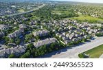 Urban sprawl mixed of apartment complex and single family houses subdivision in lush greenery area along busy E Whitestone Blvd and Brushy Creek Road in Cedar Park, Austin, Texas, aerial view. USA