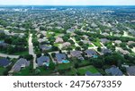 Urban sprawl with row of upscale two-story suburban home in large lot backyard, local pond with water fountain in master planned community water tower in distant background, Southlake, Texas. USA