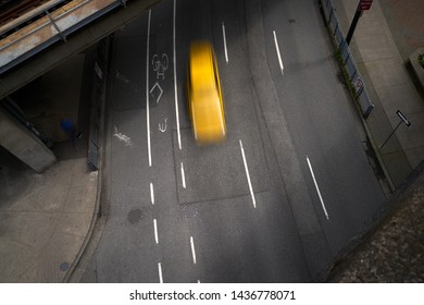 Urban Street Downtown Blur. Overhead View Of A Big City, Urban Street With A Taxi Cab. Slow Shutter Speed Creates The Motion Blur.

                               