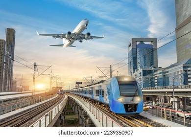 Urban view of railway tracks and suburban electric trains rushing along among high rise buildings. Passenger plane flying in sky, landing at airport. Concept of modern infrastructure transport travel - Powered by Shutterstock