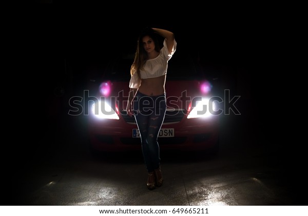 Urban young girl\
with a car in dark\
parking