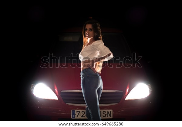 Urban young girl\
with a car in dark\
parking