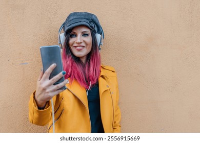 urban young woman with headphones and mobile phone in the street with yellow jacket - Powered by Shutterstock