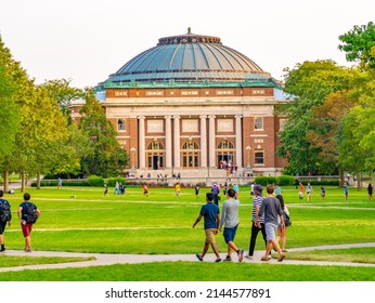 URBANA, ILLINOIS - APRIL 8, 2022:  Students walk outdoors on lawn of University of Illinois college campus quad in Urbana Champaign Illinois