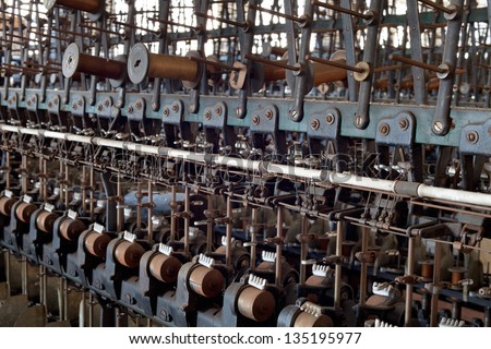 Urbex - textile industry, detail of old silk mill mechanism with bobbins, in light HDR processing