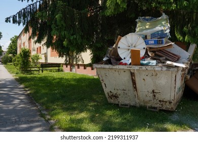 Urdorf, Switzerland 05 27 2021, Large Waste Container Filled With Bulky Waste, Old Furniture And Other Home Trash. It Is Placed On A Lawn Of A Residential Quarter. 