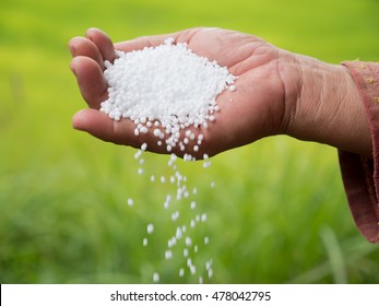 Urea Fertilizer,farmer Hand Pouring Plant Chemical Fertilizer Over Green Background