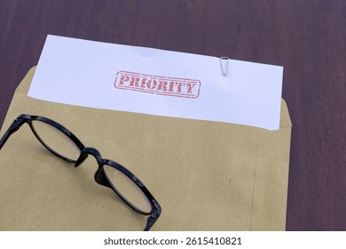 Urgency Document Theme: File with Priority Stamp and Envelope on Table