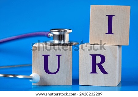 URI (Upper Respiratory Infection) - acronym on wooden large cubes on blue background with stethoscope