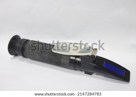 Urine specific gravity refractometer on white background.