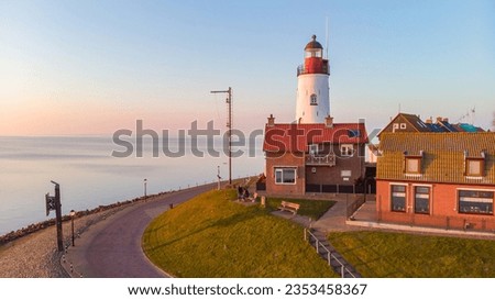 Urk Flevoland Netherlands sunset at the lighthouse and harbor of Urk Holland. Traditional Fishing Village Urk. Beautiful sunset during the evening, drone aerial view