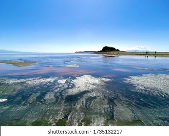 Urmia Iran -may 15 2020:main Subject Is The Sand And Pattern Of Waves On The Sand And Salt That Sedimented Close To Shore And Redness Of Artemis And Brine Shrimps And Mountains In The Background