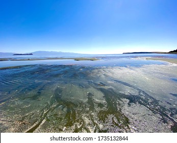 Urmia Iran -may 15 2020:main Subject Is The Sand And The Pattern Of Waves On The Sand And Salt That Sedimented Close To Shore And Redness Of Artemis And Brine Shrimps And Mountains In The Background