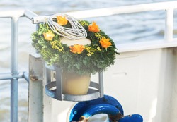 Urn With Funeral Flowers Arrangement As Burial At Sea Concept