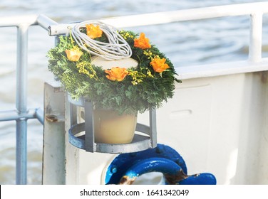 Urn With Funeral Flowers Arrangement As Burial At Sea Concept