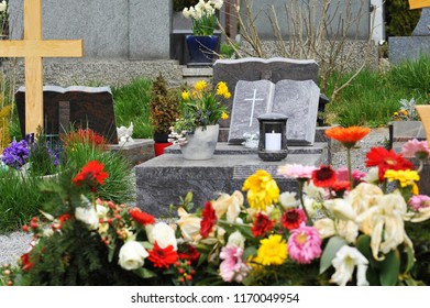 Urn Grave With Flower Arrangement And Tombstone In Form Of A Book