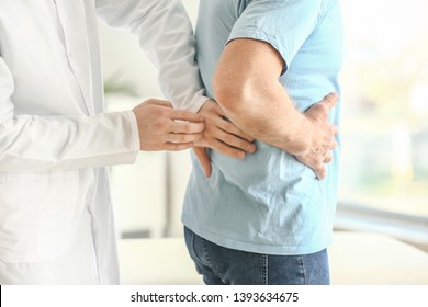 Urologist Examining Male Patient In Clinic