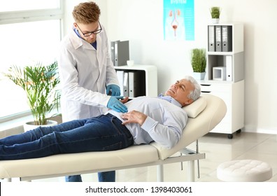 Urologist Examining Male Patient In Clinic