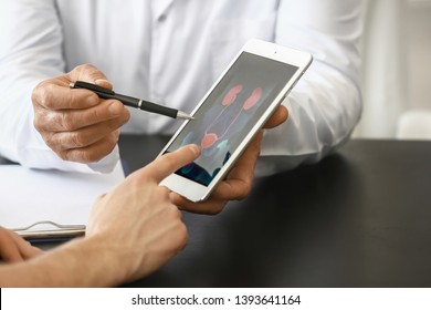 Urologist With Table Computer Explaining Patient His Diagnosis, Closeup