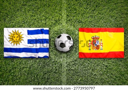 Uruguay vs. Spain flags on a green soccer field