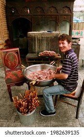 Urumqi, Xinjiang Province, P.R. China - June 30, 2012: Man Of Muslim Uighur Minority Preparing Halal Lamb Skewers For Roasting On Charcoal Grill