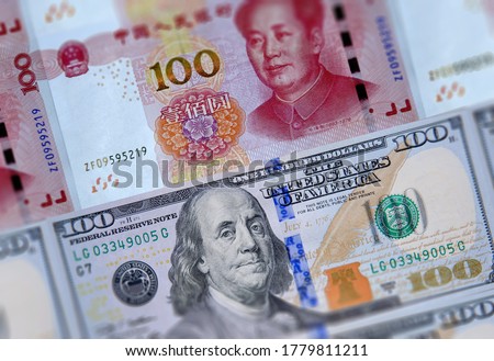 US 100 dollars bills and Chinese currency yuan banknotes closeup background. USA China business finance economic trade tension conflict, America China economies trade war, financial crisis concept