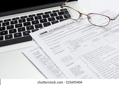 U.S. 1040 income tax return form with laptop and glasses