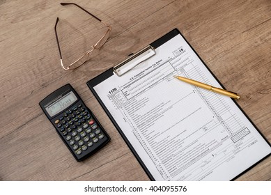 US 1120 Tax Form, Pen, Calclator On Desk