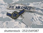 US AIR FORCE branch tape and Airman rank patch and dog tags on digital tiger-stripe pattern Airman Battle Uniform background