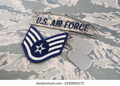 US AIR FORCE branch tape and Staff Sergeant rank patch and dog tags on digital tiger-stripe pattern Airman Battle Uniform (ABU) background - Powered by Shutterstock