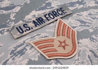 US AIR FORCE branch tape and Staff Sergeant rank patch on digital tiger stripe pattern Airman Battle Uniform background - Powered by Shutterstock