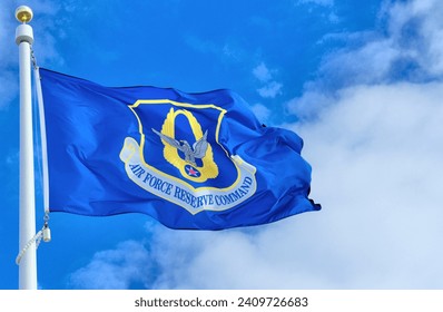 US Air Force Reserve Command flag against a blue sky and white clouds - Powered by Shutterstock