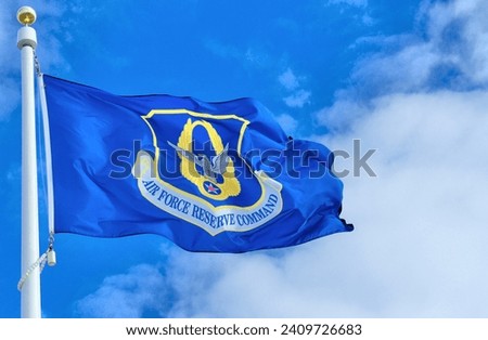 US Air Force Reserve Command flag against a blue sky and white clouds